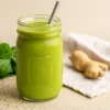 Anti-inflammatory green smoothie in a mason jar with fresh spinach and ginger