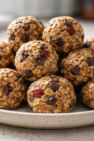 Trail mix energy bites on a plate with oats, nuts, and chocolate